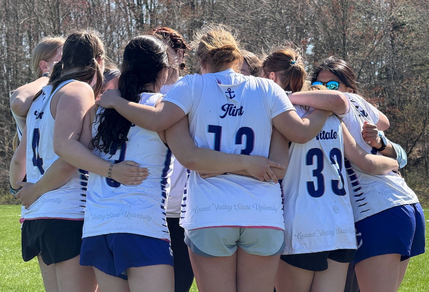 women college ultimate players in a team huddle